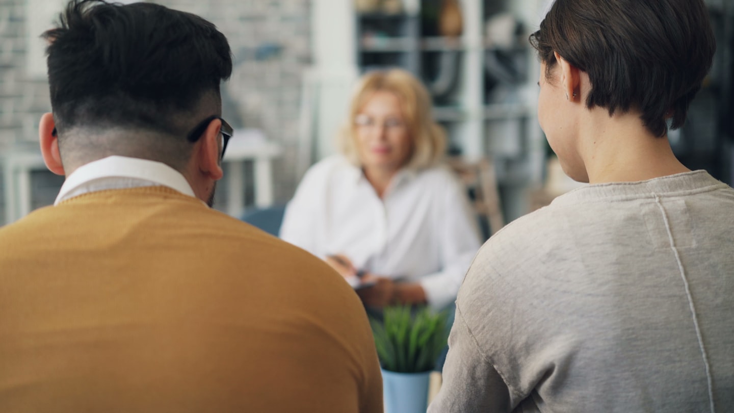 Couple in consultation with a therapist in an office.