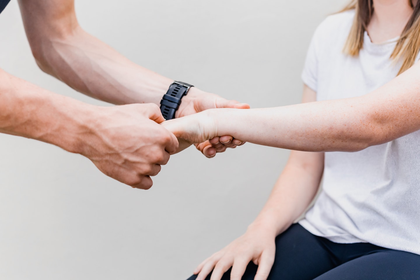 Physiotherapist examines patient's forearm and wrist.
